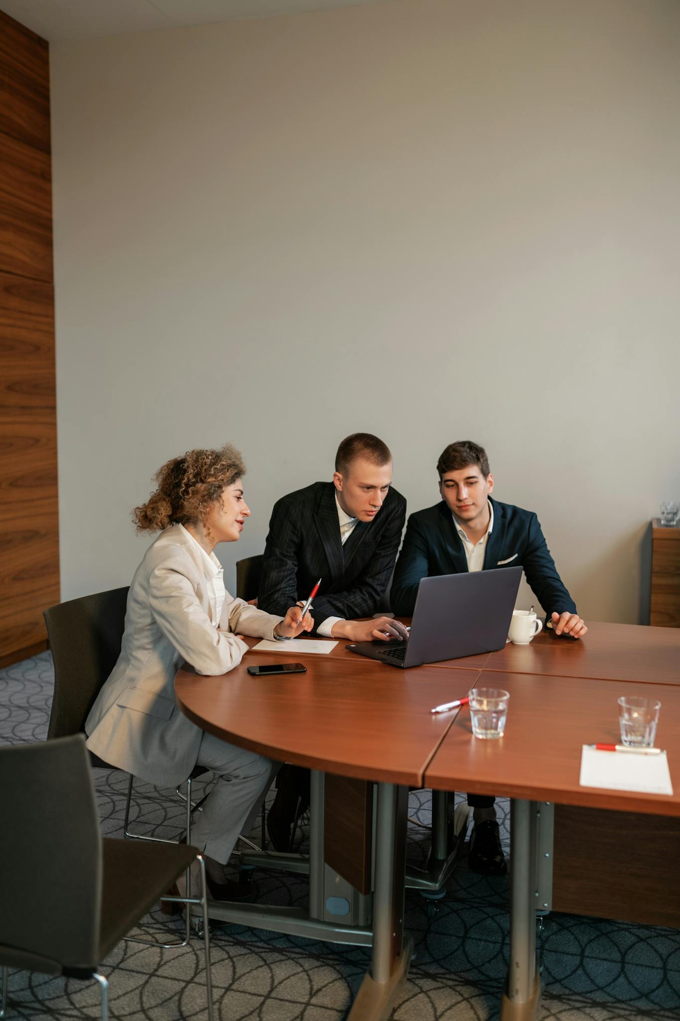 Professional setup of three people discussing a project in an office environment.